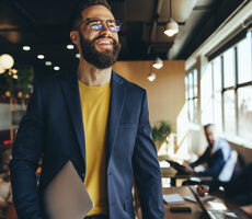 Businessman walking with laptop underarm